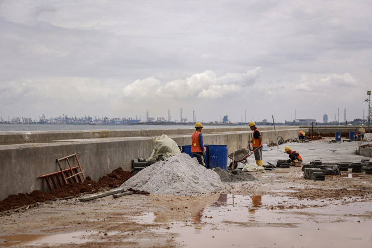 Workers work at the construction site on Dec. 19, 2025, on the National Capital Integrated Coastal Development (NCICD) seawall in the West Ancol area in North Jakarta.