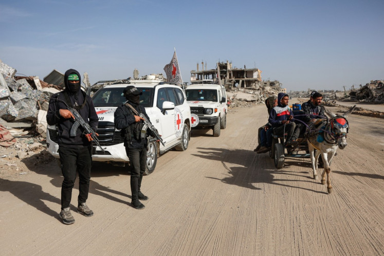 Palestinian Hamas militants secure the area as Egyptian workers accompanied by members of the International Committee of the Red Cross (ICRC) search for the remains of the last Israeli hostage in the Zeitoun neighbourhood of Gaza City on Dec. 8, 2025. Qatar and Egypt, guarantors of the Gaza ceasefire, called for the withdrawal of Israeli troops and the deployment of an international stabilization force (ISF) as the necessary next steps in fully implementing the fragile agreement.