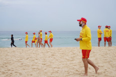 Members of Bondi Surf Life Saving Club and North Bondi Surf Life Saving Club walk on Bondi Beach in Sydney, Australia, on Dec. 20, 2025 during an event to stand shoulder to shoulder as they observe three minutes of silence to honor victims, responders and lifesavers following the mass shooting that targeted a Jewish Hanukkah celebration at Bondi Beach on Dec. 14.