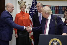 US President Donald Trump shakes hands with Merck CEO Robert Davis (left) during an event in the Roosevelt Room of the White House Dec. 19, 2025, in Washington, DC. Trump delivered remarks on lowering prescription drug prices during the event.