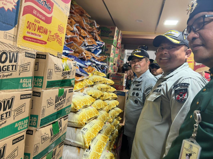 The Indonesian Maritime Security Agency (Bakamla) director of maritime air operations Cdre. Bambang Somantri (left) inspects disaster relief aid on Dec. 18 carried by KN Pulau Dana-323 patrol boat in Batam, Riau Islands. Bakamla has deployed two patrol vessels carrying a total of 160 tonnes of aid for natural disaster victims in Aceh.