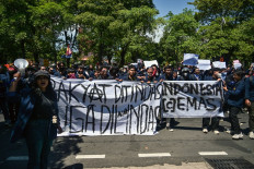 Demonstrators hold banners that read &ldquo;The people are oppressed and also run over&ldquo; (left) and &ldquo;Indonesia Cemas&ldquo; (Anxious Indonesia) right during a protest against police brutality in Surabaya, East Java on Aug. 30, 2025, following the death of an 'ojol' (online motorcycle transportation) driver who was run over by a police armored vehicle on Aug. 28 in Jakarta.
