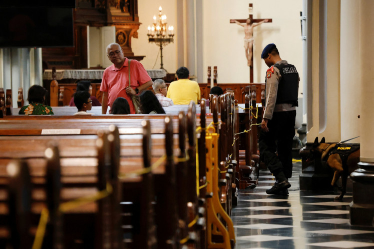 A police officer with a sniffer dog inspects the Jakarta Cathedral on Dec. 23, 2025, in preparations for Mass in Central Jakarta.