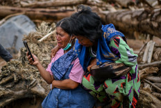 People cry during a symbolic burial ceremony on Dec. 23, 2025, for missing victims at the site of flash floods and landslides in Hutanabolon, Tukka district, Central Tapanuli, North Sumatra. The ceremony was held for families who lost relatives during the recent flash floods and landslides.