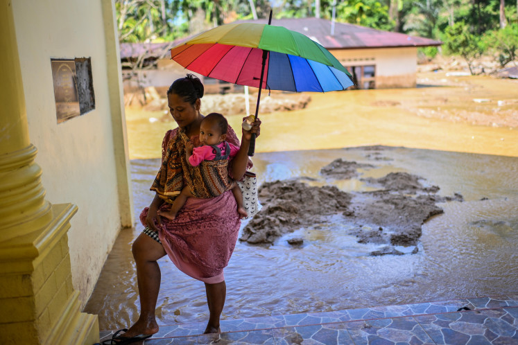 Residents affected by flash floods and landslides walk on Dec. 23, 2025, in the area of HKBP Ressort Tuka Church in Hutanabolon, Tukka District, Central Tapanuli, North Sumatra. Despite the recent disasters, the church continued to hold services ahead of Christmas.