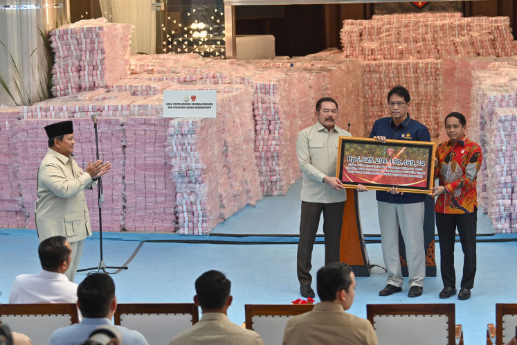 President Prabowo Subianto (left) watches as Attorney General ST Burhanuddin (second left) symbolically hands over funds on Dec. 24, 2025, collected from forestry administrative fines and recovered state assets from corruption cases to Finance Minister Purbaya Yudhi Sadewa (second right) and Forestry Minister Raja Juli Antoni (right) at the Attorney General&rsquo;s Office complex in Jakarta.