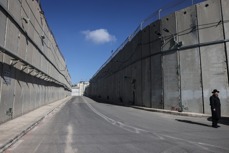 An ultra-Orthodox Jewish man stands at Israel's &ldquo;checkpoint 300&ldquo; along the controversial separation barrier near Bethlehem, in the Israeli-occupied West Bank, on Dec. 24, 2025.
