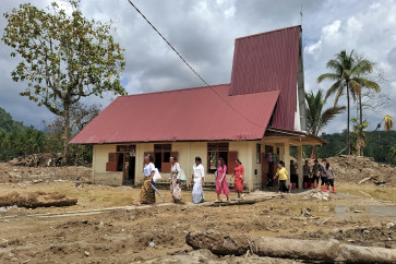 Villagers leave the Angkola Protestant Church at Aek Ngadol village, South Tapanuli regency, North Sumatra, on Dec. 25, 2025, in the aftermath of massive flooding and landslides in the area.
At a church in Sumatra, dozens of worshippers sang hymns at a Christmas service, holding their first service since floods and landslides killed more than 1,100 on the Indonesian island.