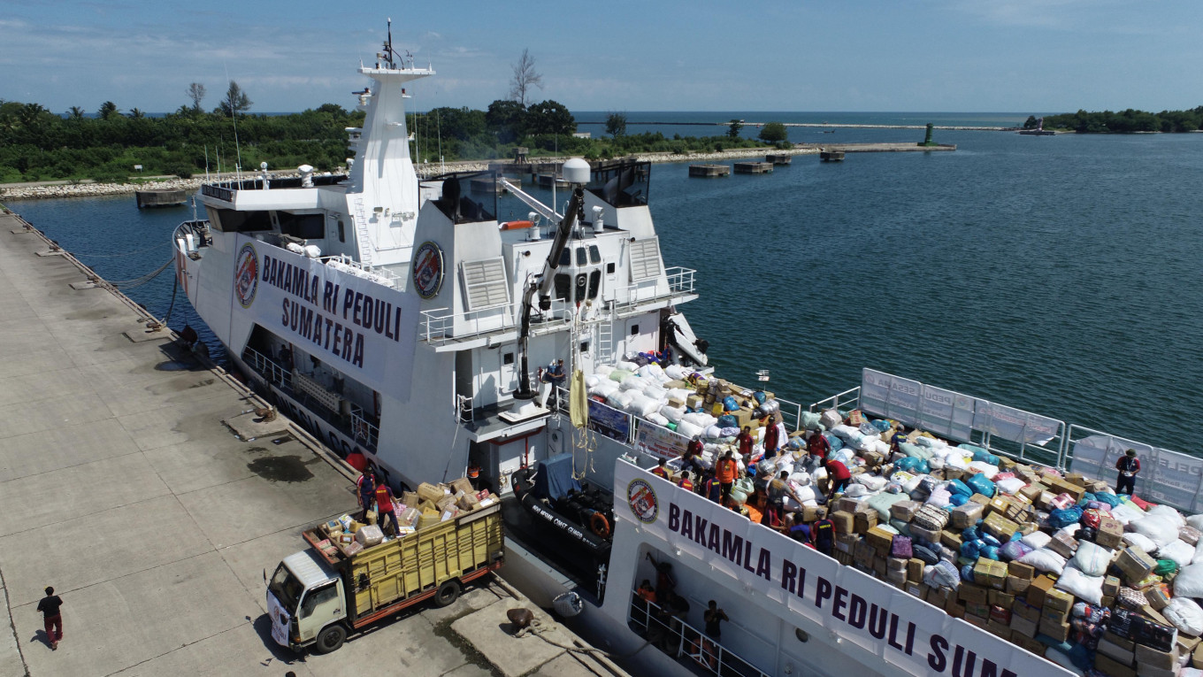 A truck (left) receives disaster relief from Indonesian Maritime Security Agency (Bakamla) patrol vessel KN Pulan Dana-323 on Dec. 22, 2025, at Krueng Geukeuh Port in Dewantara district, North Aceh regency, Aceh. The patrol ship carried 92.2 tonnes of aid for residents affected by natural disasters in North Aceh. 