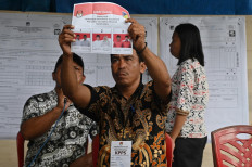 A local poll administrator (KPPS) shows a ballot to witnesses on Dec. 5, 2024, during the vote tabulation of the revote for the Central Sulawesi gubernatorial election in Palu. 