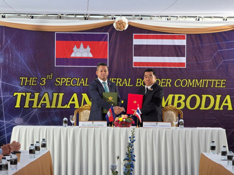 Cambodia's Defense Minister Tea Seiha and Thailand's Defense Minister Natthaphon Narkphanit pose with documents during a special General Border Committee (GBC) meeting at a border checkpoint, in Chanthaburi province, Thailand on Dec. 27, 2025.