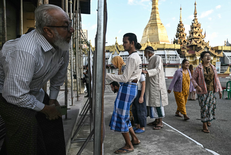 Junta gamble: People look for their name on the registry at a polling station on Dec. 28, during the first phase of Myanmar&rsquo;s general election in Yangon. Polling opened in Myanmar&rsquo;s heavily restricted junta-run elections, beginning a month-long vote democracy watchdogs describe as a rebranding of military rule.