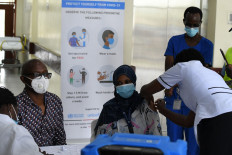 A health worker (right) administers a dose of the Oxford-AstraZeneca vaccine to a colleague at the Kenyatta National Hospital in Nairobi on March 5, 2021, under the COVID-19 Vaccines Global Access (COVAX) initiative from Gavi, the Vaccine Alliance, to combat the pandemic.