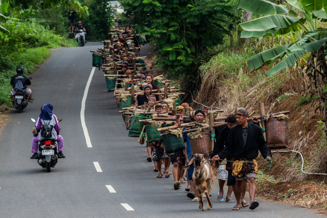 People of the Bonokeling indigenous community walk carrying food offerings during the 'Unggah-unggahan' ceremonial procession in remembrance and gratitude to their ancestors on Feb. 20, in Banyumas, Central Java. Bonokeling people from various locations walk about 40 kilometers over two days to gather at the Bonokeling cemetery, bringing livestock, rice and snacks to cook and share as a way to mark the start of the Islamic holy month of Ramadan.