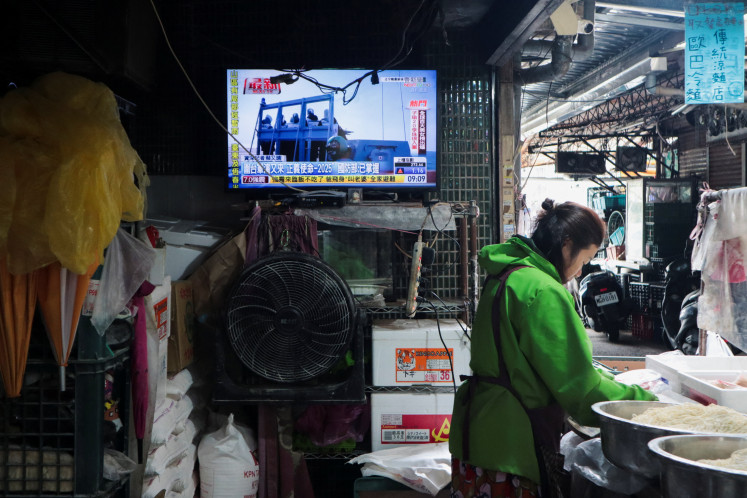 Life still goes on: A woman works in a noodle store near a television screen showing a news report on China&rsquo;s &ldquo;Justice Mission 2025&rdquo; military drills around Taiwan on Monday, Dec. 29, 2025, in Taipei.