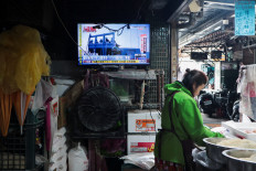 Life still goes on: A woman works in a noodle store near a television screen showing a news report on China&rsquo;s &ldquo;Justice Mission 2025&rdquo; military drills around Taiwan on Monday, Dec. 29, 2025, in Taipei.
