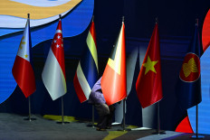 An attendant adjusts the flag for Timor-Leste after the country formally joined the ASEAN during the ASEAN Summit on Oct. 26, 2025, in Kuala Lumpur.