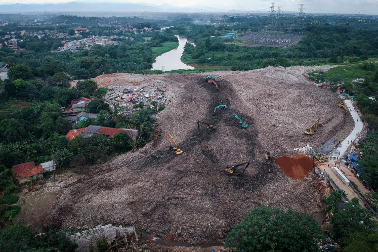 An aerial photo shows workers using excavators to remove waste at the Cipeucang final disposal site (TPA) in South Tangerang, Banten, on Dec. 26, 2025. The city administration has declared a waste management emergency, effective from Dec. 23, 2025, to Jan. 5, 2026, to speed up waste handling efforts and reduce risks to residents&rsquo; health. 