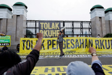An activist shouts slogans during a protest outside the Senayan legislative complex in Central Jakarta on Dec. 5, 2022 as the House of Representatives is set to pass a new Criminal Code (KUHP) that will ban sex outside marriage, cohabitation between unmarried couples, insulting the president and expressing views counter to the national ideology.