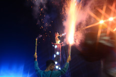 A man sets off fireworks on Jan. 1, 2026, during New Year celebrations at the Hotel Indonesia traffic circle in Central Jakarta, Indonesia. Indonesia limited New Year celebrations and banned official fireworks displays in solidarity with victims of recent catastrophic floods in Sumatra.