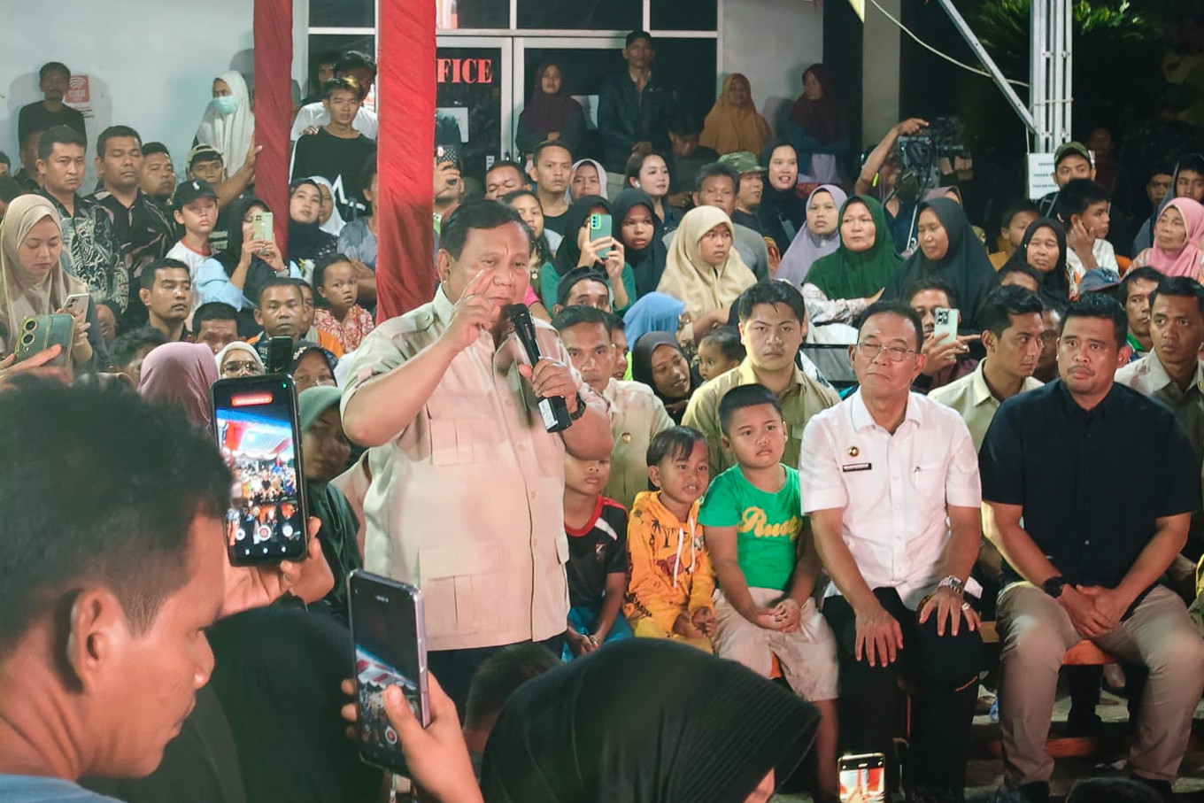President Prabowo Subianto (center) addresses displaced people during a gathering on Dec. 31, 2025, at an evacuation center in Batu Hula village, South Tapanuli regency, North Sumatra, as North Sumatra Governor Bobby Nasution (right, front row) and South Tapanuli Regent Gus Irawan Pasaribu (second right, front row) look on.