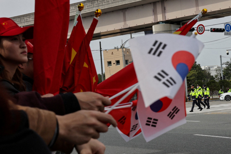 Pro-China supporters hold China and South Korea flags near Gimhae International Airport in Busan, South Korea on Oct. 30, 2025, the day of a bilateral meeting between United States President Donald Trump and Chinese President Xi Jinping on trade tensions and bilateral relations on the sidelines of the Asia-Pacific Economic Cooperation (APEC) Summit.
