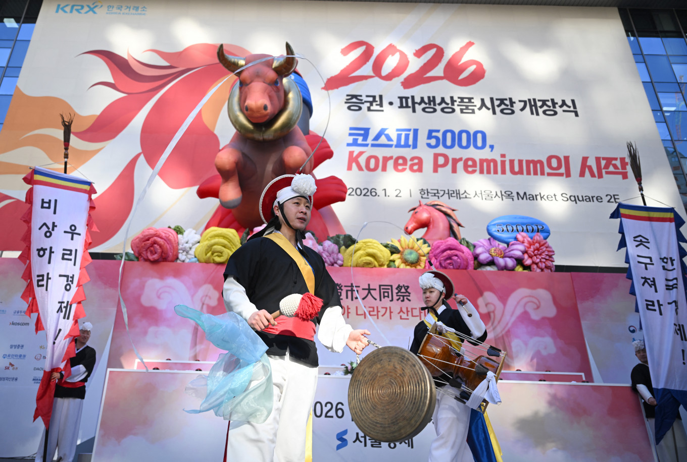 Traditional dancers perform beneath inflatable figures of a bull (left) and a horse (right) during a ceremony celebrating the New Year's opening of the South Korea stock market at the Korea Exchange in Seoul on Jan. 2, 2026.