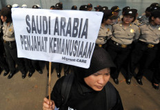 An activist holds a banner reading &ldquo;Saudi Arabia, is a criminal of humanity&ldquo; during a protest against the execution of Indonesian migrant worker Ruyati outside the Saudi Arabian embassy in Jakarta, in this file photo taken on June 21, 2011.