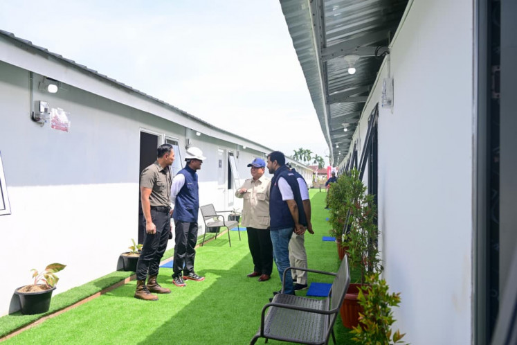 President Prabowo Subianto (center) speaks to Coordinating Infrastructure and Regional Development Minister Agus Harimurti Yudhoyono (left), State-Owned Enterprises (SOEs) Regulatory Agency head Dony Oskaria (second left) and state asset fund Danantara CEO Rosan Roeslani (second right) and Aceh Governor Muzakir Manaf during an inspection on Jan. 1 of a temporary housing site for residents affected by floods and landslides in Aceh Tamiang regency, Aceh. 