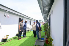 President Prabowo Subianto (center) speaks to Coordinating Infrastructure and Regional Development Minister Agus Harimurti Yudhoyono (left), State-Owned Enterprises (SOEs) Regulatory Agency head Dony Oskaria (second left) and state asset fund Danantara CEO Rosan Roeslani (second right) and Aceh Governor Muzakir Manaf during an inspection on Jan. 1 of a temporary housing site for residents affected by floods and landslides in Aceh Tamiang regency, Aceh. 