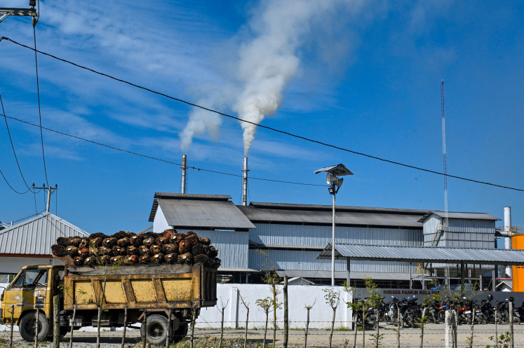 A truck laden with fresh fruit bunches is parked on May 30, 2025, outside a palm oil processing factory in Meulaboh, Aceh.