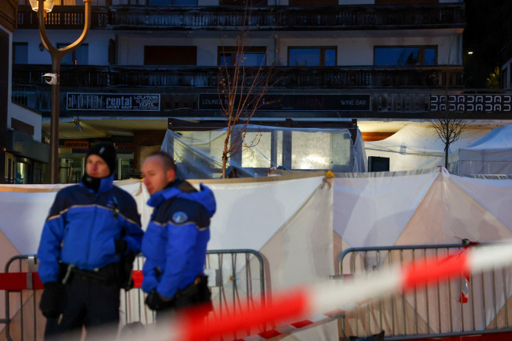Police officers stand guard in front of the Le Constellation bar after a fire and explosion during a New Year's Eve party in which people died and others were injured in the upscale ski resort of Crans-Montana in southwestern Switzerland, on Jan. 2, 2026.