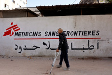 A Palestinian man walks on his crutches to the Doctors Without Borders or Medecins Sans Frontieres (MSF) clinic in the al-Rimal neighborhood of Gaza City on Dec. 31, 2025. Israel has said 37 aid organisations will be banned from operating in Gaza from Jan. 1, 2026, unless they comply with guidelines requiring detailed information on Palestinian staff, drawing criticism from the United Nations and the European Union.