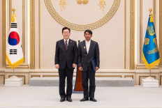 Indonesian migrant worker Sugianto stands next to South Korean President Lee Jae-myung on Dec. 2, 2025, during an award ceremony at the Blue House in Seoul. Sugianto received a presidential honor for his bravery in rescuing elderly residents during a massive forest fire in South Korea in March 2025.