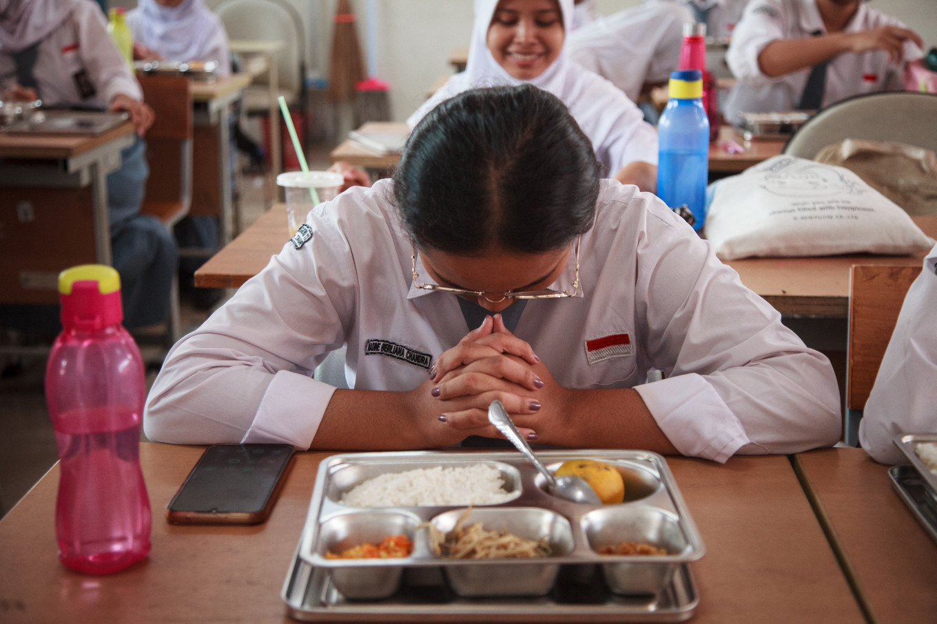 A student prays before lunch on Jan. 6, 2025, the first day of the government&rsquo;s free nutritious meal program at State Senior High School 11 in East Jakarta.
