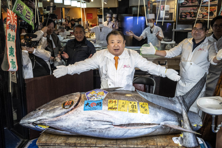 Bluefin bonanza: Kiyoshi Kimura (center), president of Kiyomura Corp., the Tokyo-based operator of sushi restaurant chain Sushizanmai, displays a 243-kilogram bluefin tuna on Jan. 05, 2026, at his main restaurant in Tokyo, after the New Year&rsquo;s auction at Toyosu fish market.