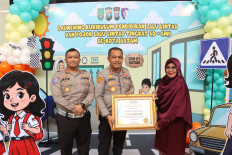 Batam Rempang Galang (Barelang) City Police traffic police chief Comr. Afiditya Arief Wibowo (left) accompanies Barelang City Police chief Sr. Comr. Zaenal Arifin (center) on Dec. 17, 2025, in handing over a plaque marking the launch of the Traffic Corner to a school representative in Batam, Riau Islands. The Barelang City Police also signed a memorandum of understanding (MoU) with the Batam city administration to include traffic education in elementary and junior high school curriculums.