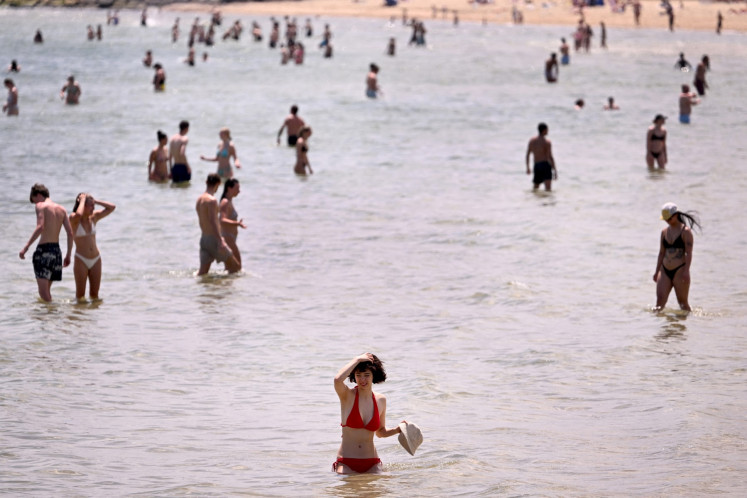 People cool off in heatwave conditions at Melbourne's St Kilda Beach on November 22, 2024.