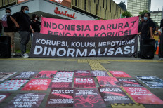 Protesters hold banners that read &ldquo;Indonesia Darurat Bencana Korupsi&ldquo; (Indonesia in emergency disaster of corruption) (top) and &ldquo;Korupsi, kolusi, nepotisme dinormalisasi&ldquo; (Corruption, collusion and nepotism normalized) (bottom) during a protest on Dec. 9, 2025, to commemorate the International Anti-Corruption Day in Jakarta.