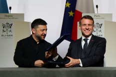 Ukraine&rsquo;s President Volodymyr Zelenskiy (left) and France&rsquo;s President Emmanuel Macron react on Jan. 6, 2026, upon the signing of the declaration on deploying a post-ceasefire force in Ukraine during the so-called &ldquo;Coalition of the Willing&rdquo; summit, at the Elysee Palace in Paris.