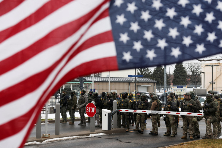  Homeland Security Investigations (HSI) and Border Patrol stand guard, while an upside down U.S flag flutters, while demonstrators protest against the fatal shooting of Renee Nicole Good by a U.S. Immigration and Customs Enforcement (ICE) agent, during a rally against increased immigration enforcement across the city, outside the Whipple Building in Minneapolis, Minnesota, U.S., January 8, 2026. 