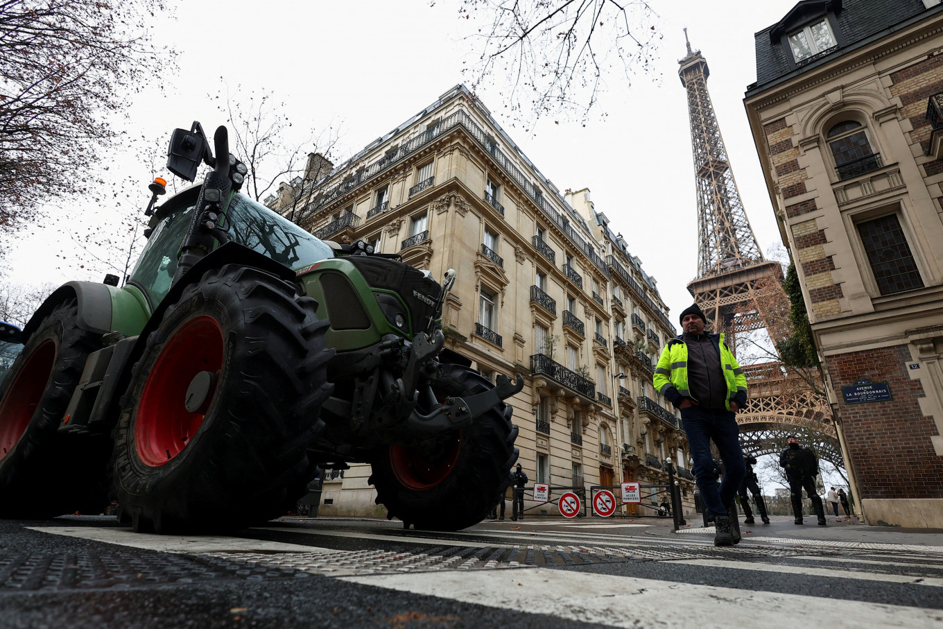 Police officers stand next to tractors blocking a road near the Eiffel Tower, as French farmers protest against the government's handling of the EU-Mercosur free trade agreement and the handling of the lumpy skin disease outbreak, in Paris on Jan. 8, 2026. REUTERS/Gonzalo Fuentes     TPX IMAGES OF THE DAY