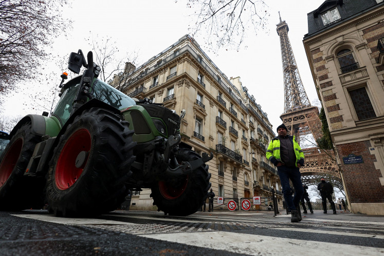 Police officers stand next to tractors blocking a road near the Eiffel Tower, as French farmers protest against the government's handling of the EU-Mercosur free trade agreement and the handling of the lumpy skin disease outbreak, in Paris on Jan. 8, 2026. REUTERS/Gonzalo Fuentes     TPX IMAGES OF THE DAY