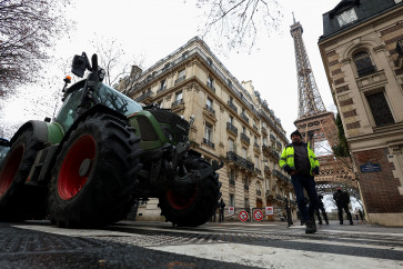Police officers stand next to tractors blocking a road near the Eiffel Tower, as French farmers protest against the government's handling of the EU-Mercosur free trade agreement and the handling of the lumpy skin disease outbreak, in Paris on Jan. 8, 2026. REUTERS/Gonzalo Fuentes     TPX IMAGES OF THE DAY