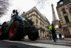 Police officers stand next to tractors blocking a road near the Eiffel Tower, as French farmers protest against the government's handling of the EU-Mercosur free trade agreement and the handling of the lumpy skin disease outbreak, in Paris on Jan. 8, 2026. REUTERS/Gonzalo Fuentes     TPX IMAGES OF THE DAY