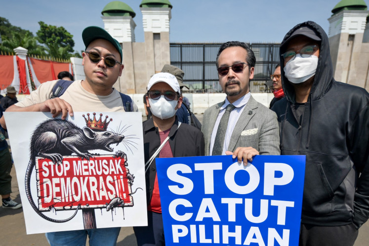 Protesters holds placards that read 'Stop destroying democracy' (left) and 'Stop revoking our votes' (right) during a protest in front of the Senayan legislative complex in Jakarta on Aug. 22, 2024 against the House of Representative's plan to reverse the Constitutional Court ruling on eligibility rules for regional election candidates.