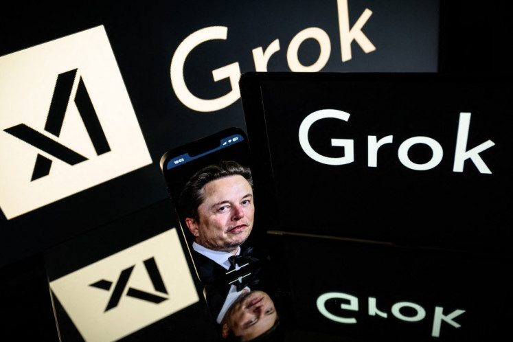 This photograph taken on Jan. 13, 2025 in Toulouse shows screens displaying the logo of Grok, a generative artificial intelligence chatbot developed by xAI, the American company specializing in artificial intelligence and it's founder South African businessman Elon Musk.
