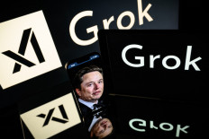 This photograph taken on Jan. 13, 2025 in Toulouse shows screens displaying the logo of Grok, a generative artificial intelligence chatbot developed by xAI, the American company specializing in artificial intelligence and it's founder South African businessman Elon Musk.