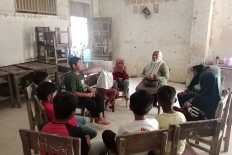 A teacher (center right, top) leads students in a classroom lesson on Jan. 5, 2026, at a reopened school in Kejuruan Muda district, Aceh Tamiang regency, Aceh, one of three provinces in northern Sumatra that were struck by flooding and landslides in late November.
