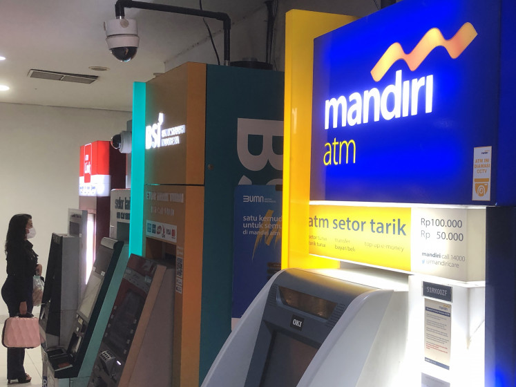 A woman stands in front of an ATM on Jan. 11 inside a shopping mall in East Jakarta. 